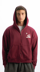 Person wearing a maroon hoodie with a logo on a white background